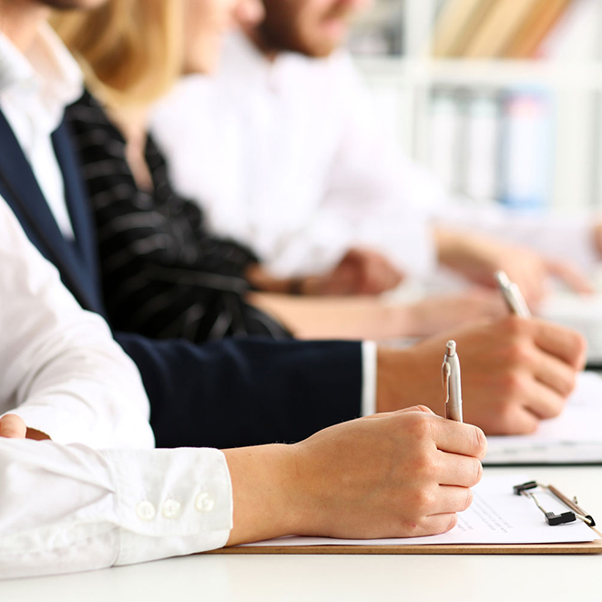 Group of people hold silver pen