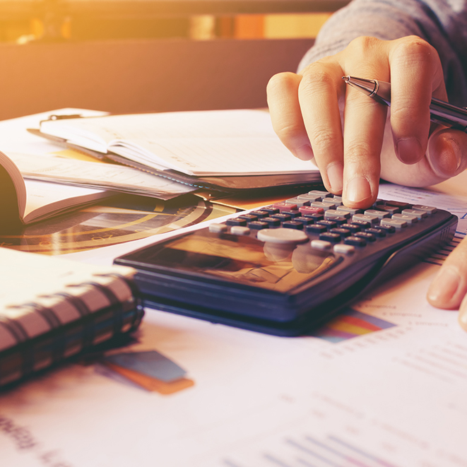 Woman using calculator with doing finance at home office.