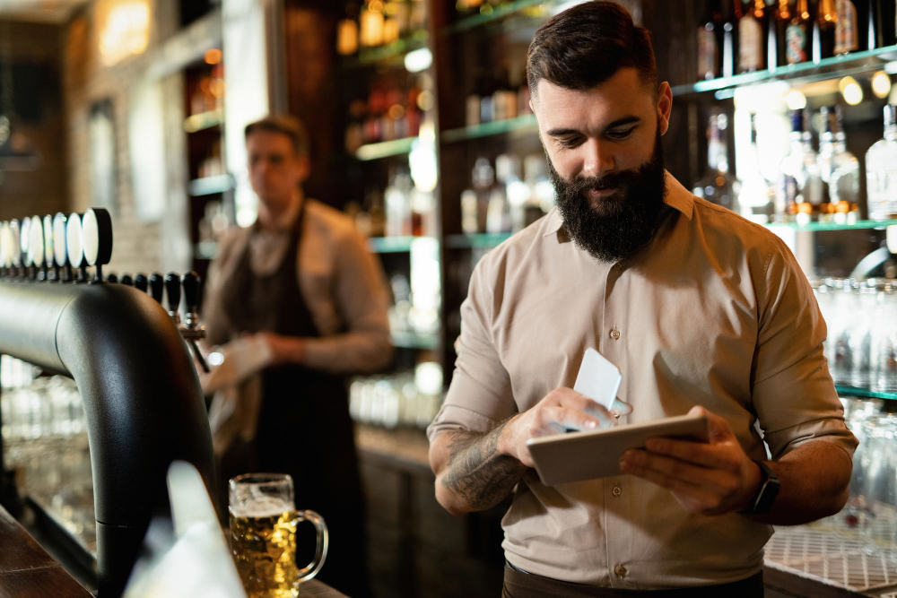 joven barista feliz trabajando bar navegando red panel tactil.jpg