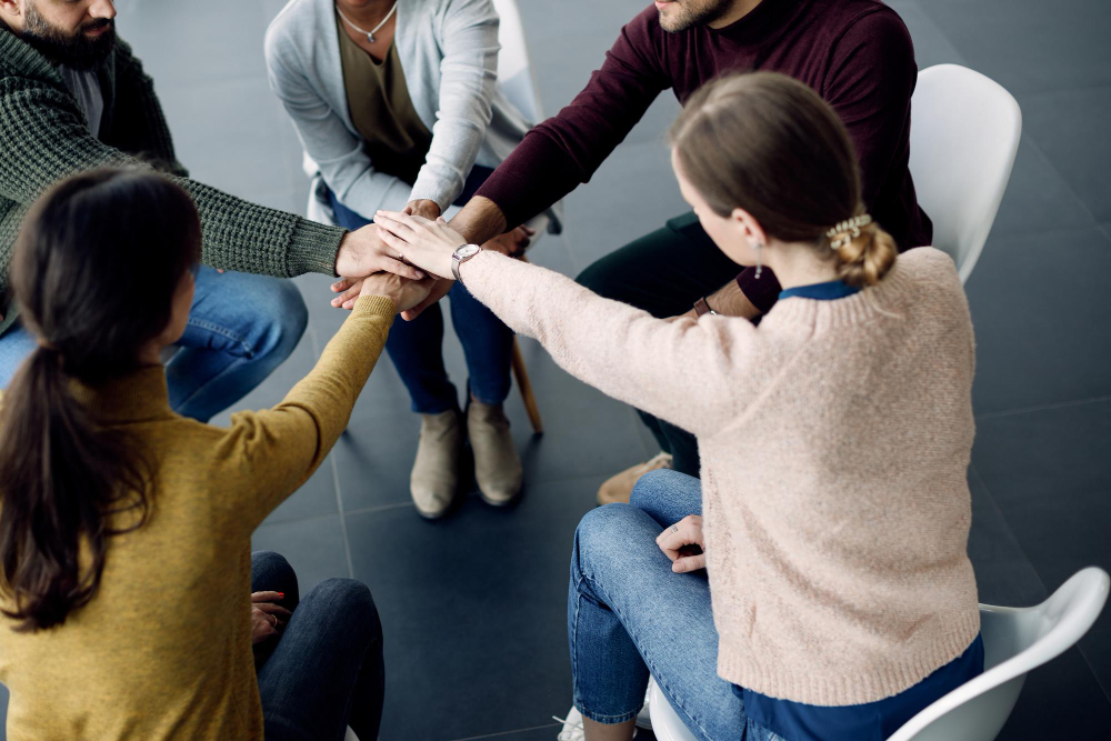 participantes terapia grupo juntando manos unidad sesion centro medico.jpg